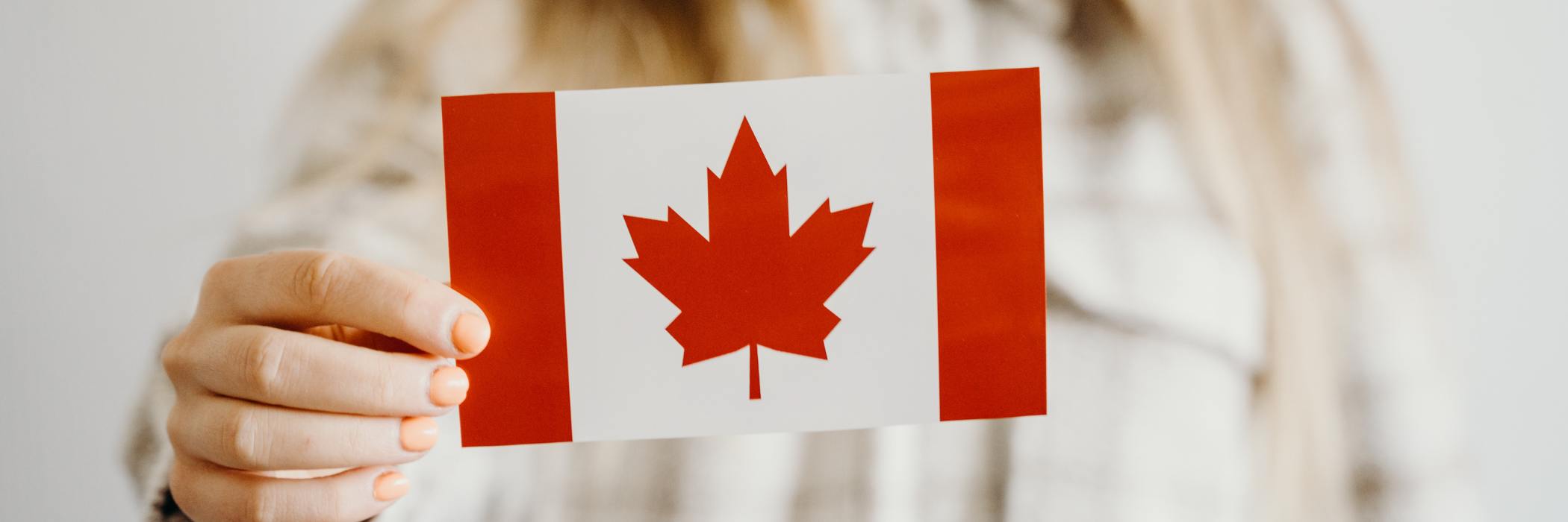 Woman holding small Canadian flag.