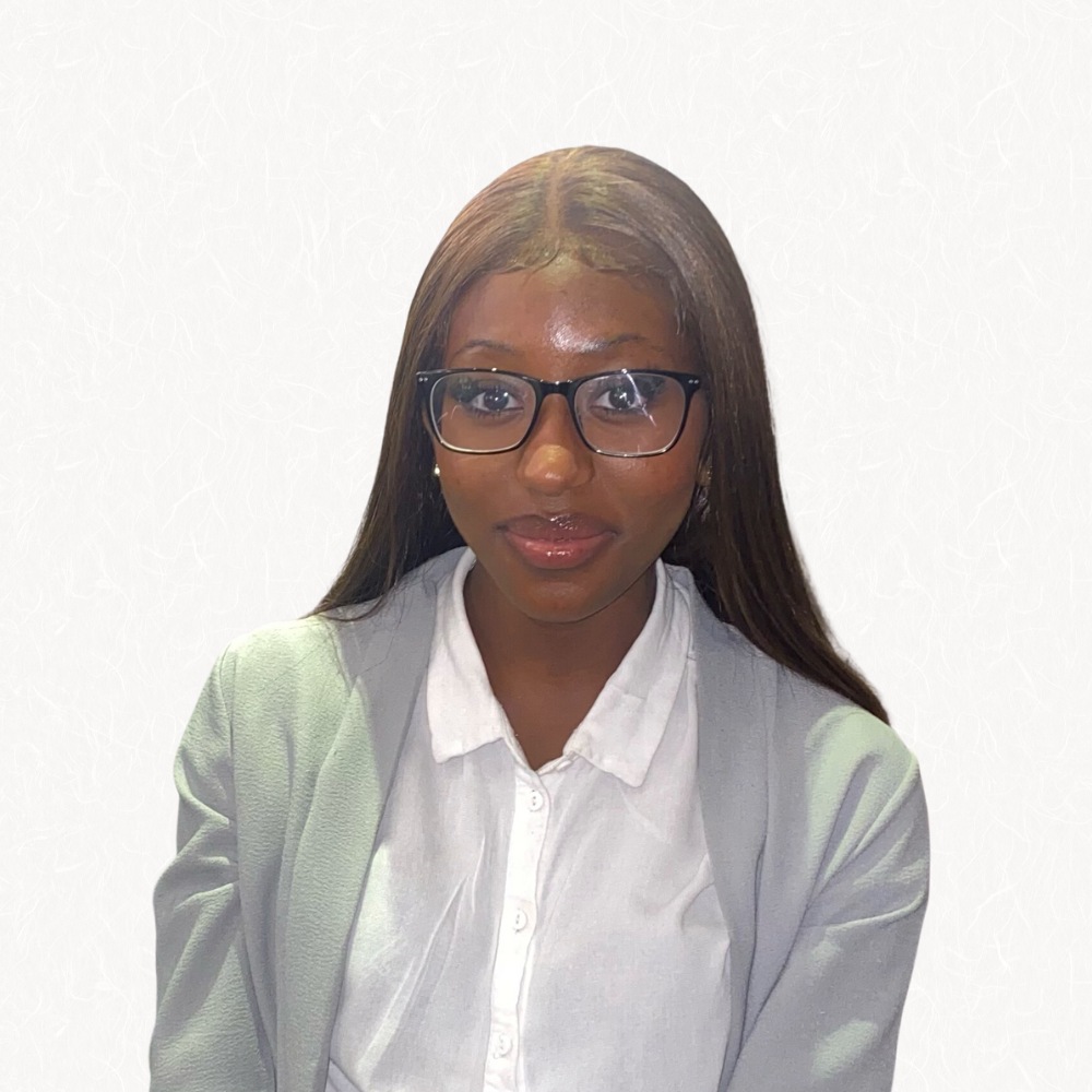 Headshot of woman wearing glasses and a grey blazer with white shirt.