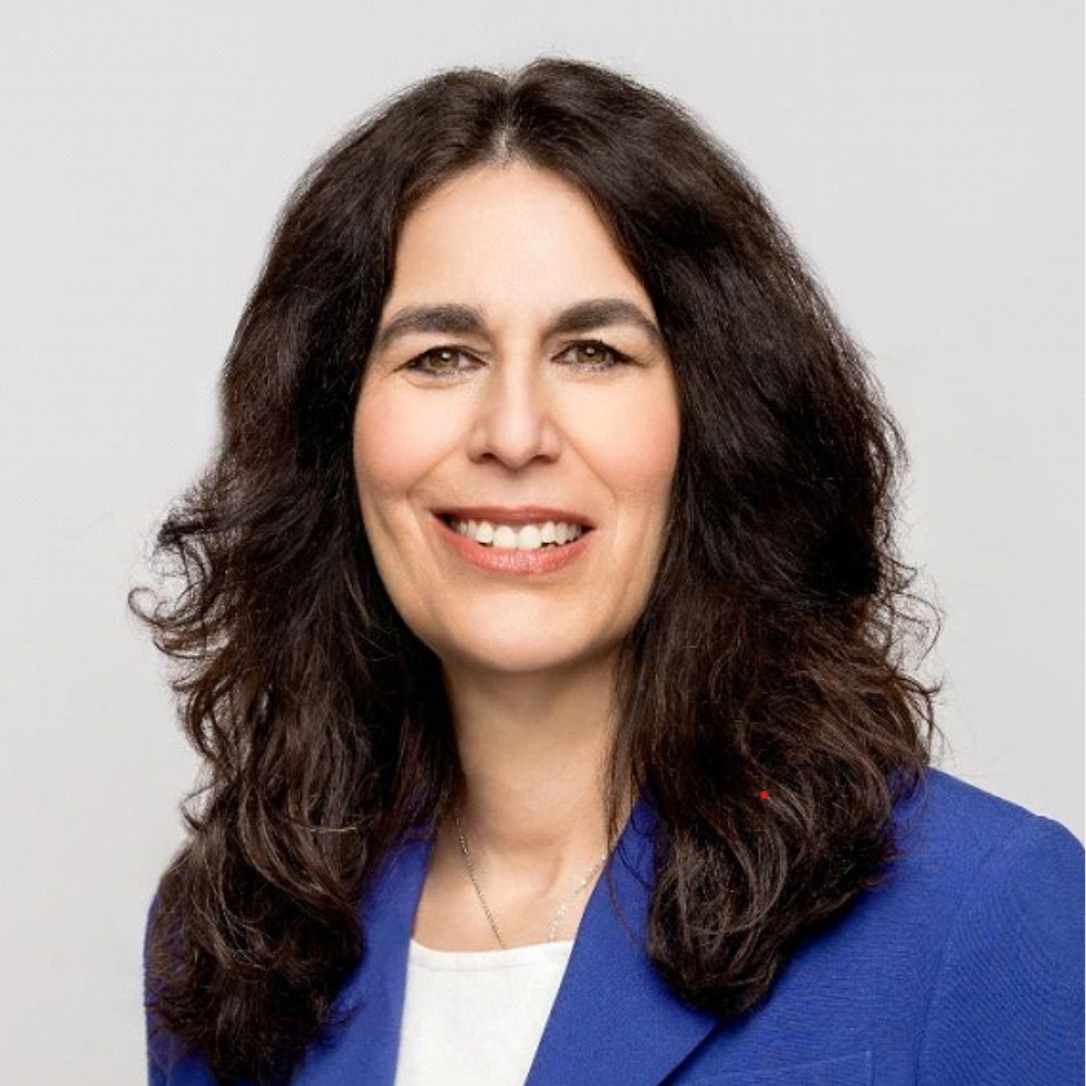 Headshot of woman with dark hair and a blue blazer.